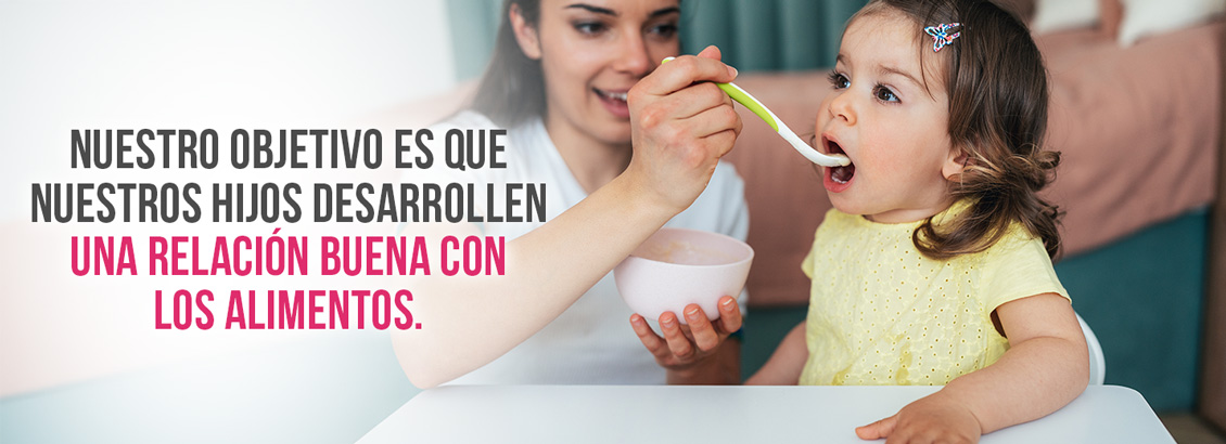 Mamá dando de comer a su hija, quien recibe su comida sin problemas
